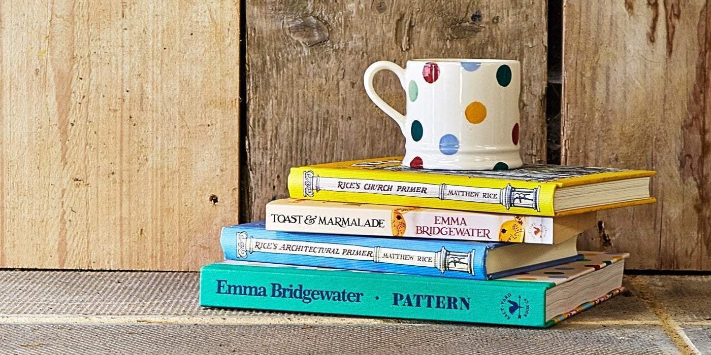 Stacked Emma Bridgewater coffee table books with a colourful polka dot mug makes an ideal partner while reading.