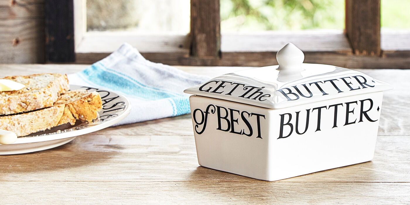 Keep better fresh and spreadable anytime you need it with a traditional butter dish with lid. Pictured: white, rectangular pottery butter dish with vintage style, black letterings by Emma Bridgewater.